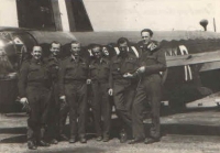 Irvingova posádka před wellingtonem na základně East Wretham nedlouho poté, co se šťastně vrátili ze základny v Granthamu, kde museli 8. 5. 1942 nouzově přistát. Však je úleva na všech dobře vidět. Zleva: Al. Novák (př. stř.), Jiří Böhm (zadní stř.), Jan Irving (kapitán a velitel pos.), Frant. Švejdar (RTG), Jos. Stach (2. pilot), Jos. Němeček (nav.).
